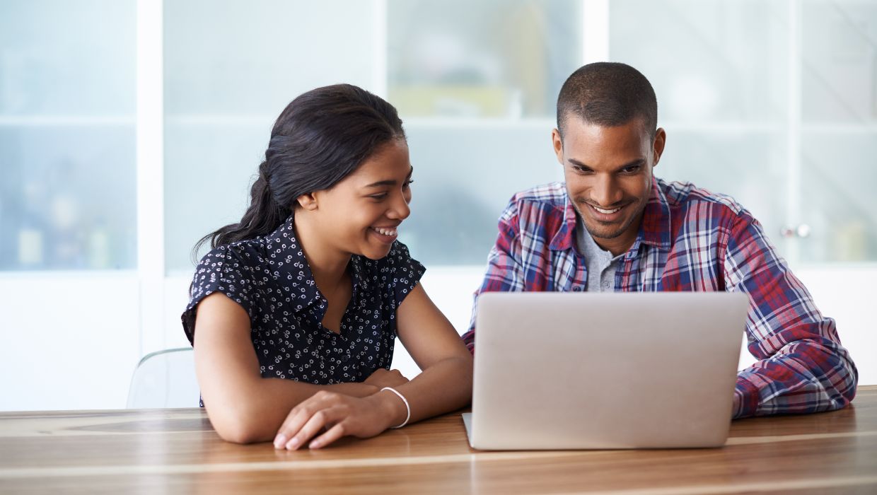 Two people looking at a laptop screen tile